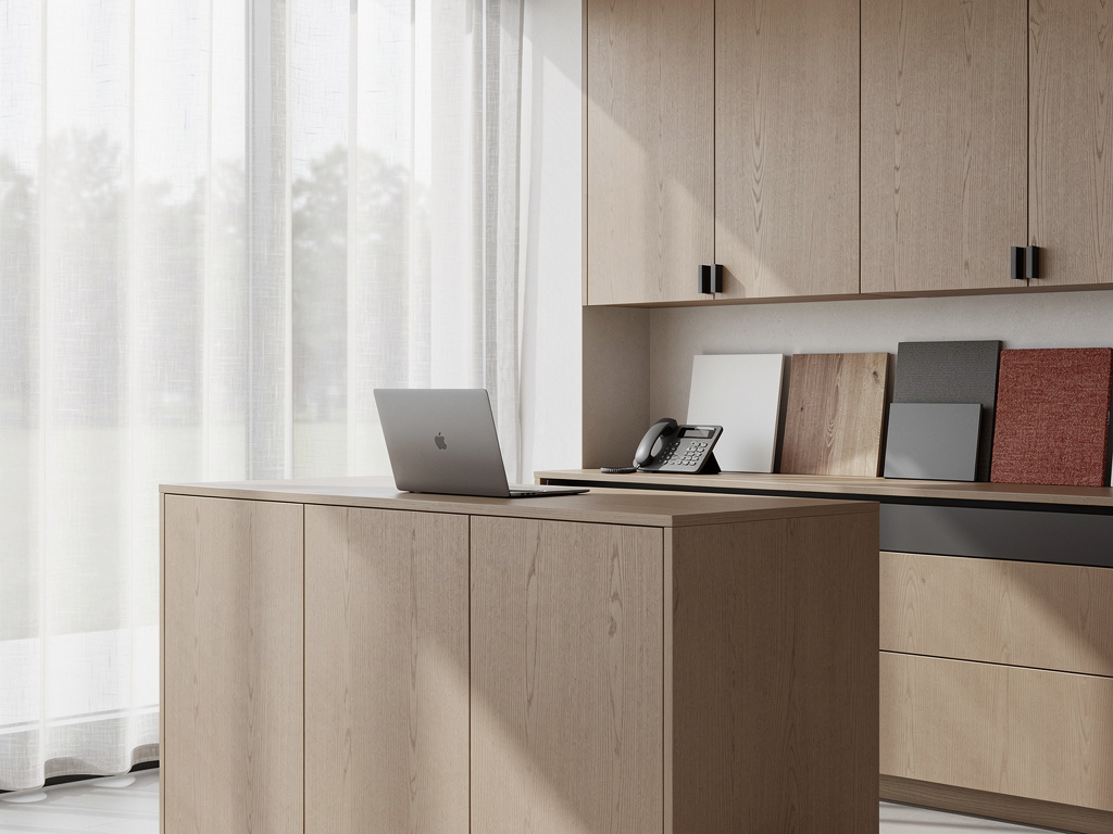 A calm showroom entrance with a wood reception desk, a laptop and a phone, material samples on display and soft daylight